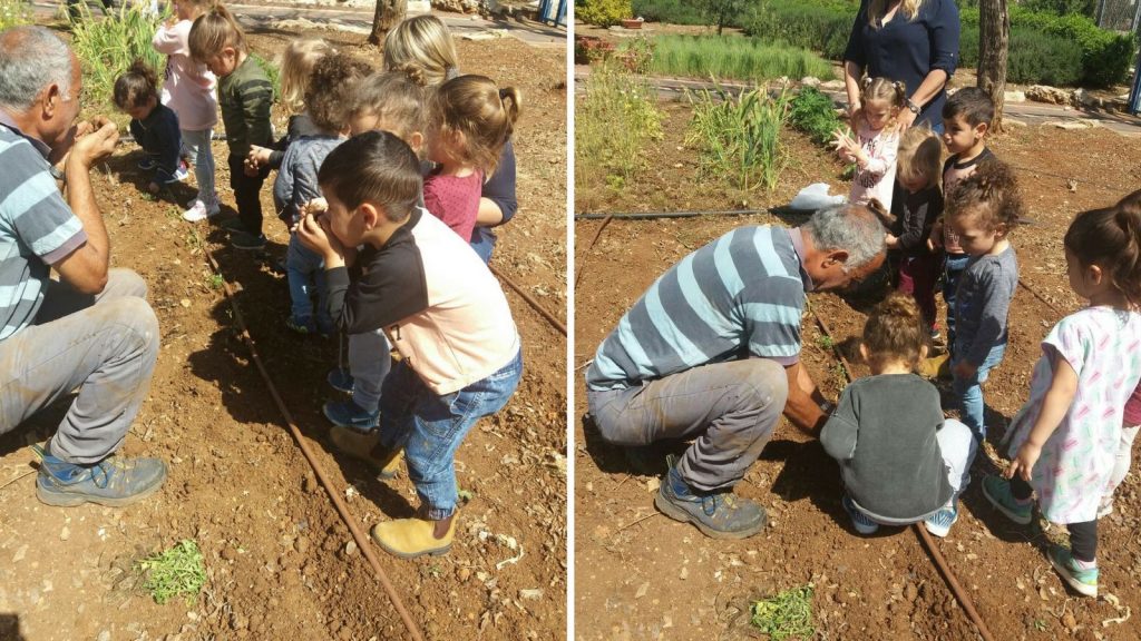 ילדים לצד ערוגה מקבלים הסבר מאדם מבוגר